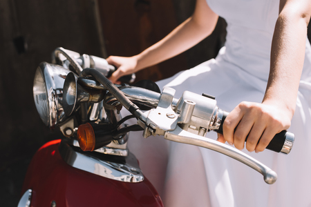 cropped view of bride sitting on vintage scooterの写真素材