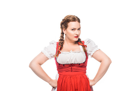 confident oktoberfest waitress in traditional bavarian dress standing with hands on waist isolated on white backgroundの写真素材