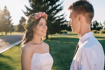 beautiful happy young wedding couple looking at each other in parkの写真素材