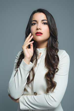 stylish brunette girl posing in white suit, isolated on greyの写真素材