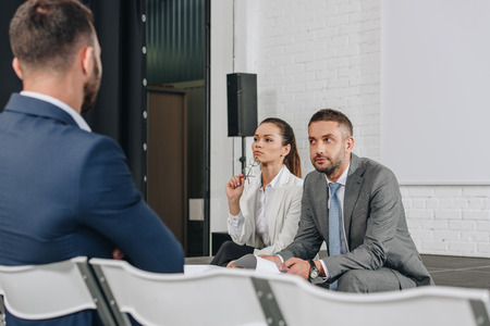 business trainers sitting on stage with documents in hubの写真素材