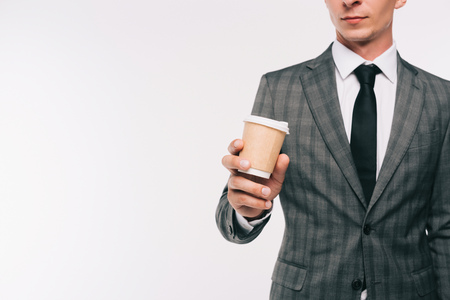 cropped image of businessman holding coffee in paper cup isolated on whiteの写真素材