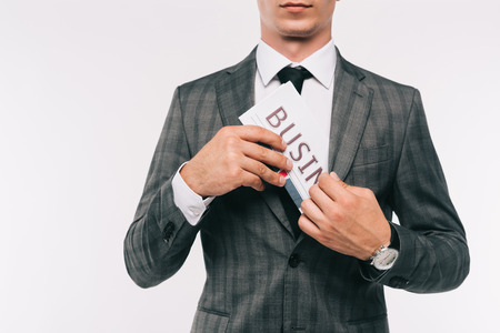 cropped image of businessman putting newspaper in jacket pocket isolated on whiteの写真素材