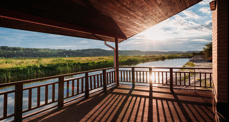 wide shot of of beautiful sunset over river from wooden terraceの写真素材