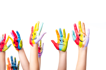 cropped image of schoolchildren showing painted hands with smiley icons isolated on whiteの写真素材