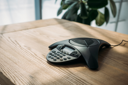 conference phone on wooden table at officeの写真素材
