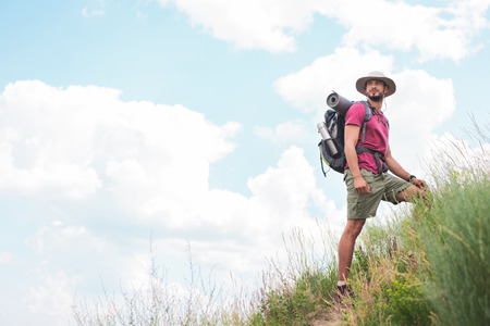 male hiker in hat with backpack and tourist matの写真素材