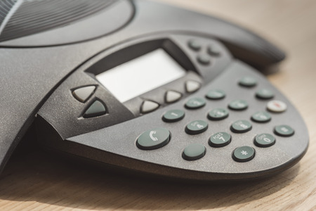 partial of speakerphone on wooden table at officeの写真素材
