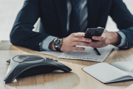 cropped shot of businessman using smartphone at workplaceの写真素材