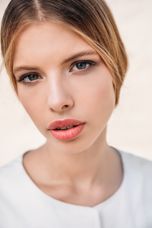 portrait of beautiful blonde woman posing in white clothesの写真素材