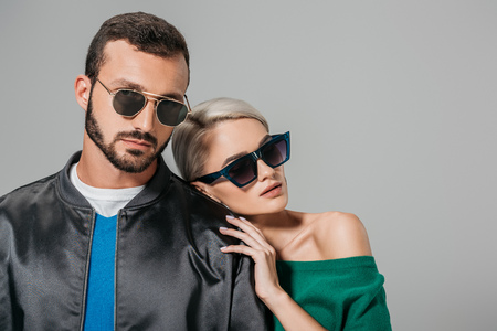 stylish couple posing in sunglasses for fashion shoot, isolated on greyの写真素材