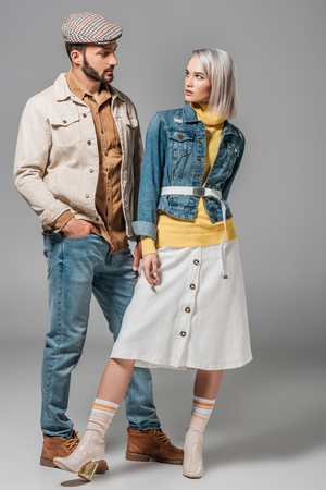couple posing in autumn outfit and looking at each other, on greyの写真素材