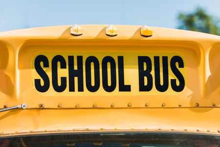 close-up shot of school bus inscription over front window of bus