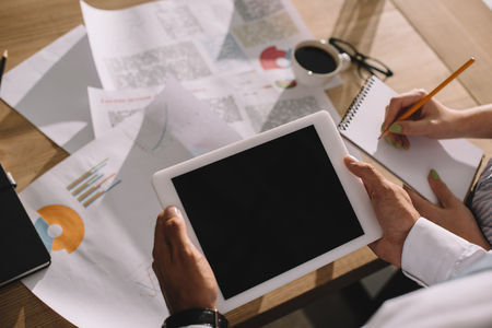 businesspeople using digital tablet and doing paperwork in officeの写真素材