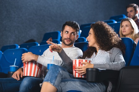 couple with popcorn watching movie together in cinemaの写真素材