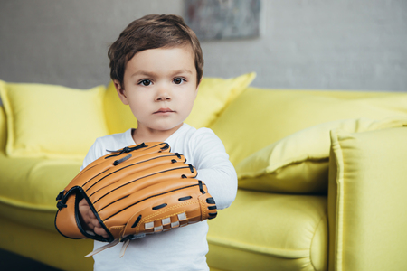 adorable little boy playing with baseball gloveの写真素材