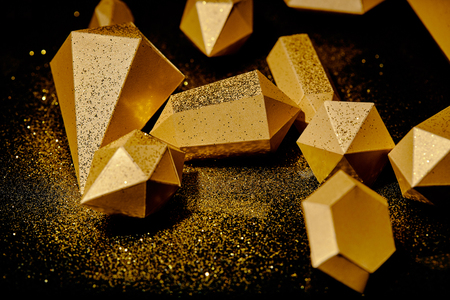 close-up view of shiny golden pieces and dust on blackの写真素材