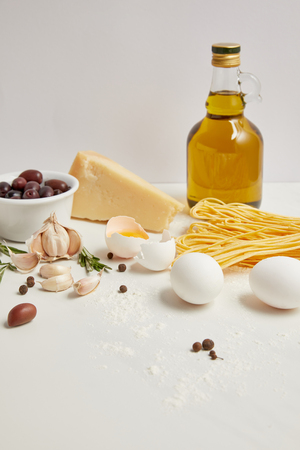 close up view of arranged ingredients for cooking italian pasta on white tabletopの写真素材