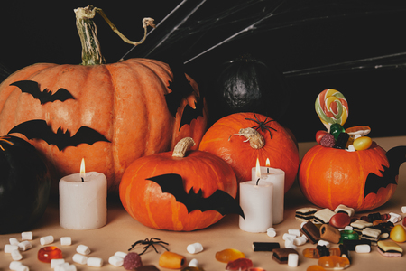 pumpkins, jelly candies, marshmallows and paper bats on table, halloween conceptの写真素材