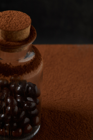 close-up view of gourmet chocolate balls in glass jar and cocoa powderの写真素材