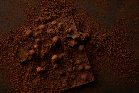 top view of delicious chocolate pieces with nuts on dark background