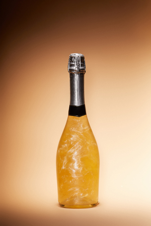 bottle of glittering champagne isolated on beige, christmas conceptの写真素材