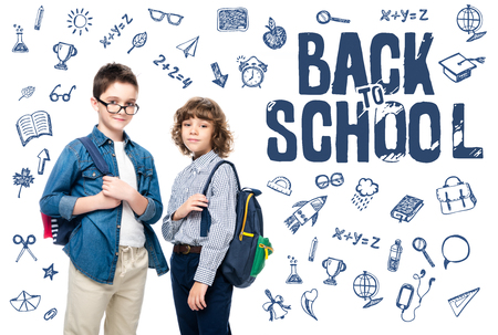 two schoolboys with backpacks looking at camera isolated on white, with icons and "back to school" letteringの写真素材