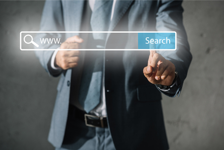 cropped view of developer in formal wear touching website search barの写真素材