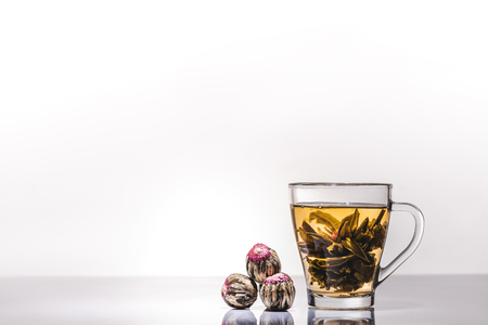 cup of chinese flowering tea with tea balls on tableの写真素材