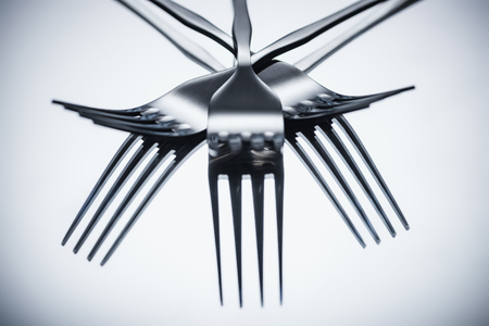 close-up view of shiny stainless steel forks reflected on greyの写真素材