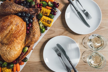 flat lay with roasted turkey, vegetables and glasses of wine for thanksgiving holiday dinner on tabletopの写真素材