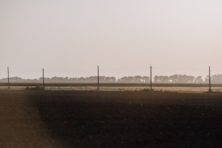 rural scene with field and electric towers in countrysideの写真素材