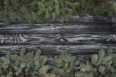 top view of beautiful evergreen fir branches on wooden background