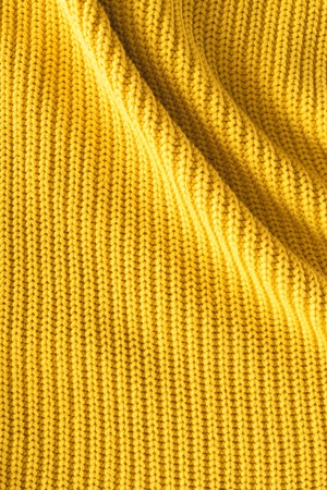 close up view of wavy yellow woolen fabric as backdrop