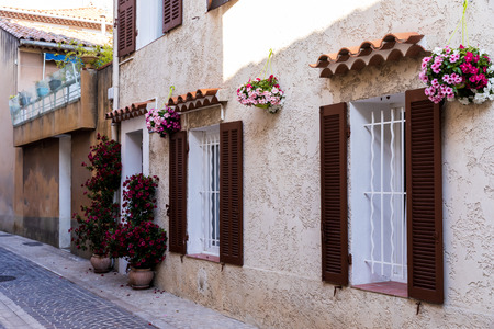cozy narrow street with traditional houses, flower pots and shutters in provence, franceの写真素材
