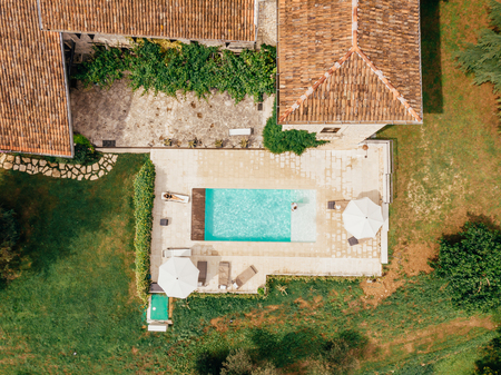 top view of man and woman resting at swimming pool near villa in Italy