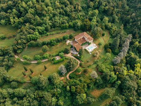aerial view of villa with swimming pool between forest in Italyの写真素材