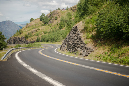 empty winding asphalt road in beautiful green mountains, Aurlandsfjord, Flam (Aurlandsfjorden), Norwayの写真素材