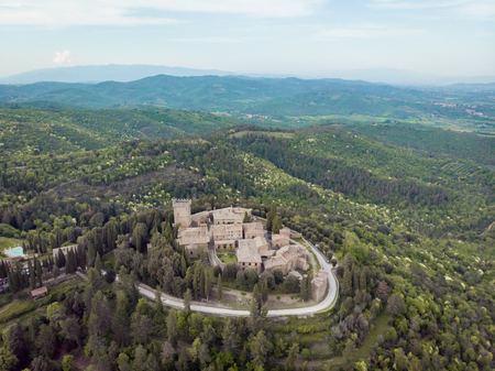 GARGONZA, ITALY - JUNE 1, 2018: aerial view of Castle of Gargonza on hill with trees around, Italyの写真素材