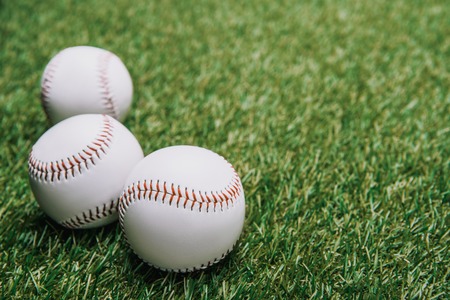 close up view of white baseball balls on green lawnの写真素材