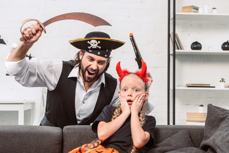 portrait of daughter and father in halloween costumes playing at homeの写真素材