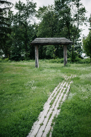 footpath made of wooden planks and wooden gate in green parkの写真素材