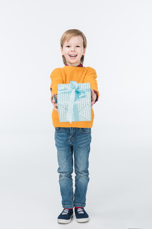 happy boy with gift box looking at camera isolated on whiteの写真素材