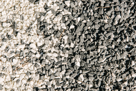 top view of black and white pebble stones for backgroundの写真素材