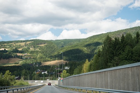 TRYSIL, NORWAY - 26 JULY 2018: road with cars near forest and mountains at largest ski resort Trysil in Norwayのeditorial素材
