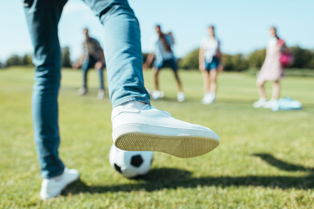 cropped shot of boy playing soccer with friends in parkの写真素材