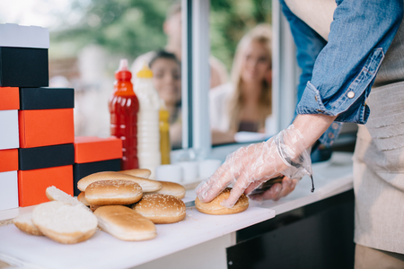 cropped shot of male chef cutting buns white cooking at food truckの写真素材