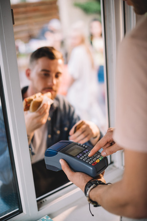 selective focus of customer paying for hot dog in food truckの写真素材
