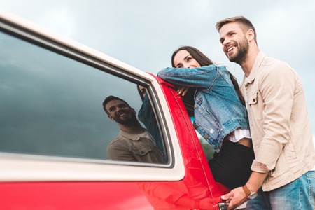 Beautiful young couple near vintage red truck on cloudy day
