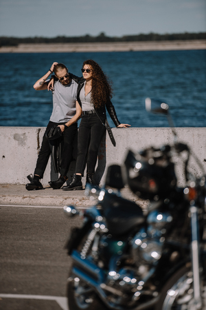 selective focus of young couple with motorcycle on foregroundの写真素材